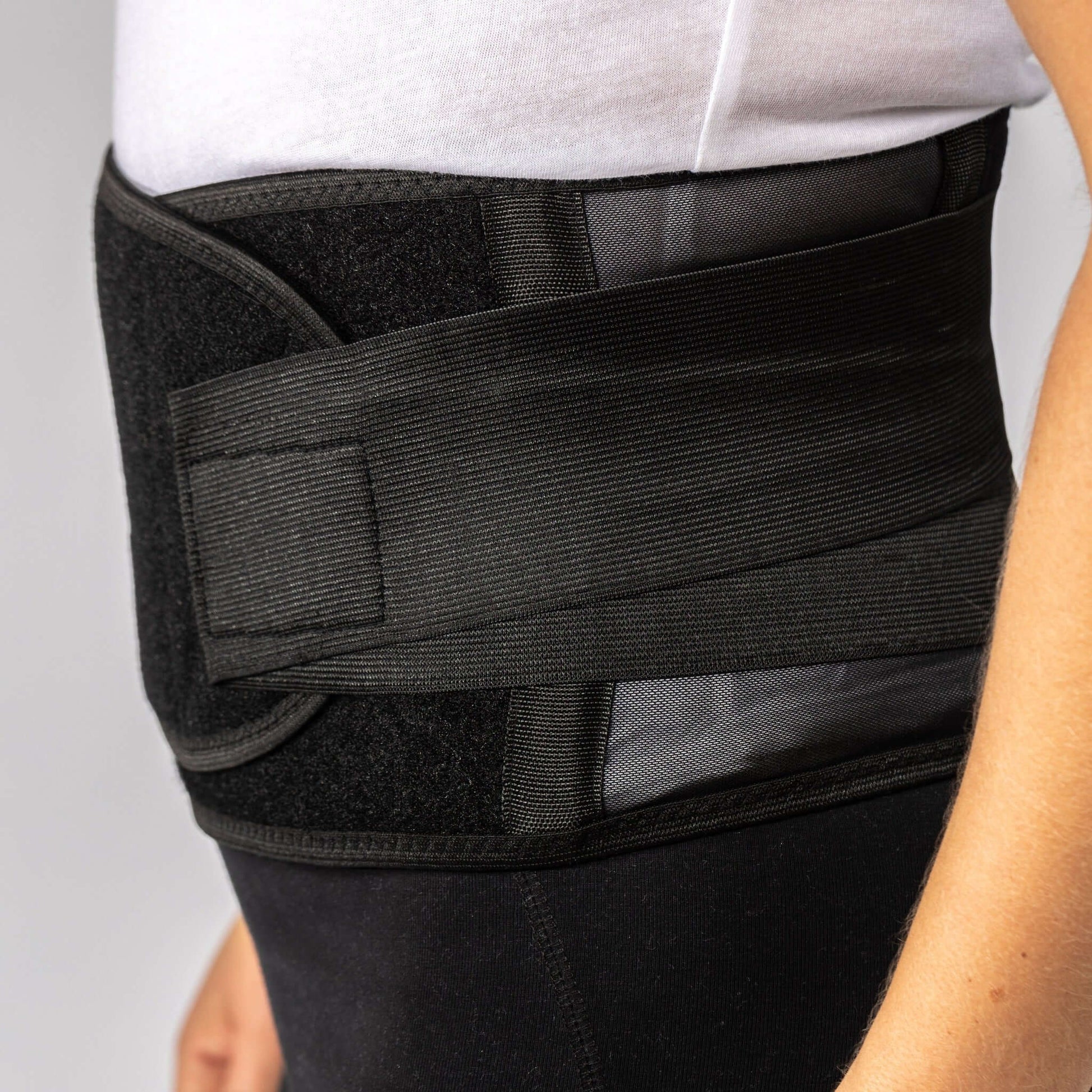 Side view of woman wearing a Bio magnetic Back Support Brace with vented sides and strong support.
