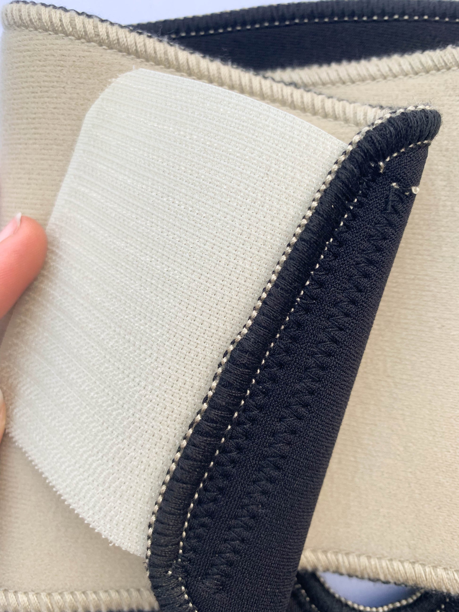 The inside of the adhesive tab on the Bio Magnetic Knee Support Beige, showing the strong adhesive closure of this support.