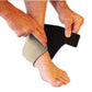 Step 2 in the process of how to wear for the magnetic ankle support. A person has secured the magnetic ankle support around the heal of their foot and are now beginning to wrap the magnetic ankle support across the top of their foot. 