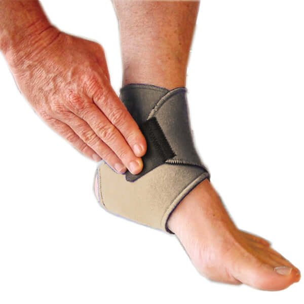 A person has put on the bio magnetic ankle support in beige, they are using their hand to press down on the adhesive closure in the last step to secure the magnetic ankle support around their ankle.  