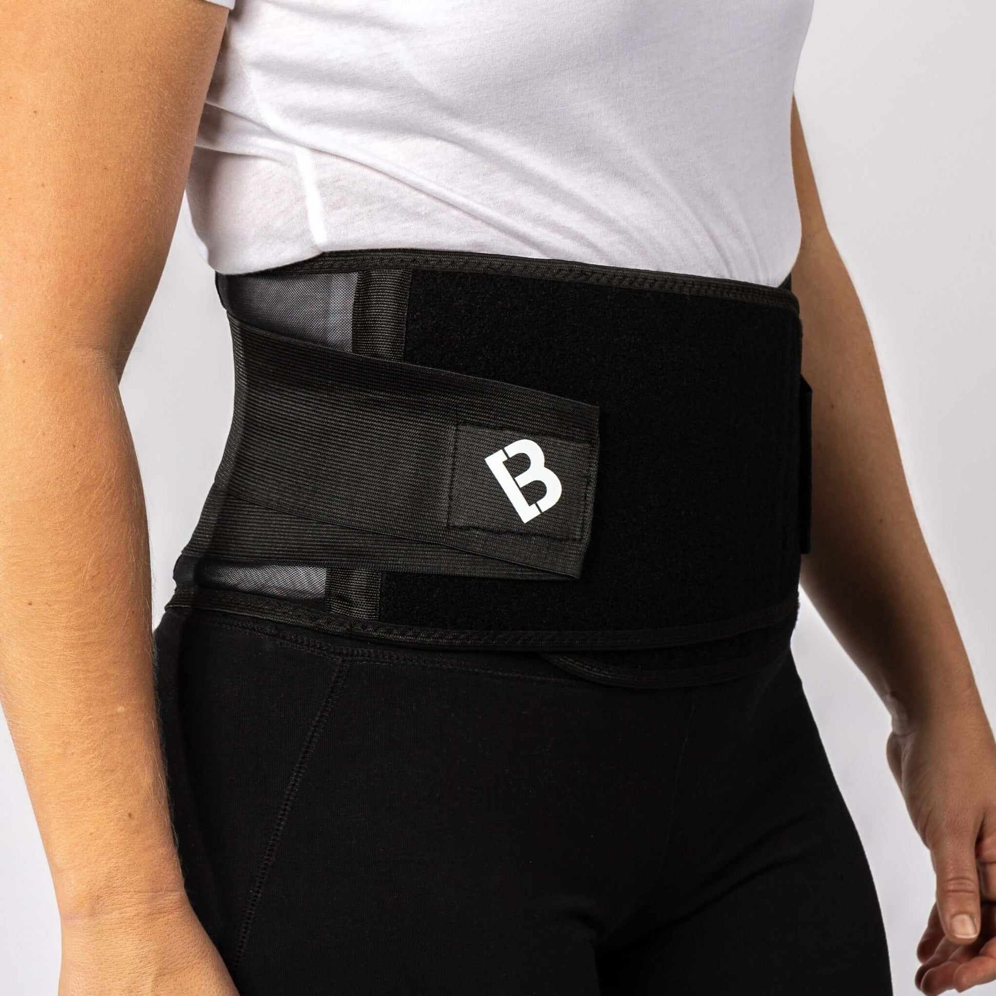 Woman wearing the Bio Magnetic Back Support Brace with vented sides and 20 therapeutic magnets. 