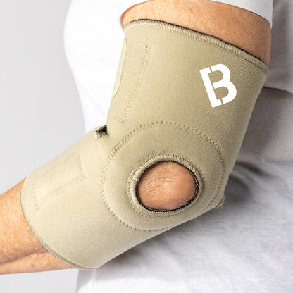 Beige Bio Magnetic Elbow Support on Elderly Woman, elbow slightly bent and view from the back