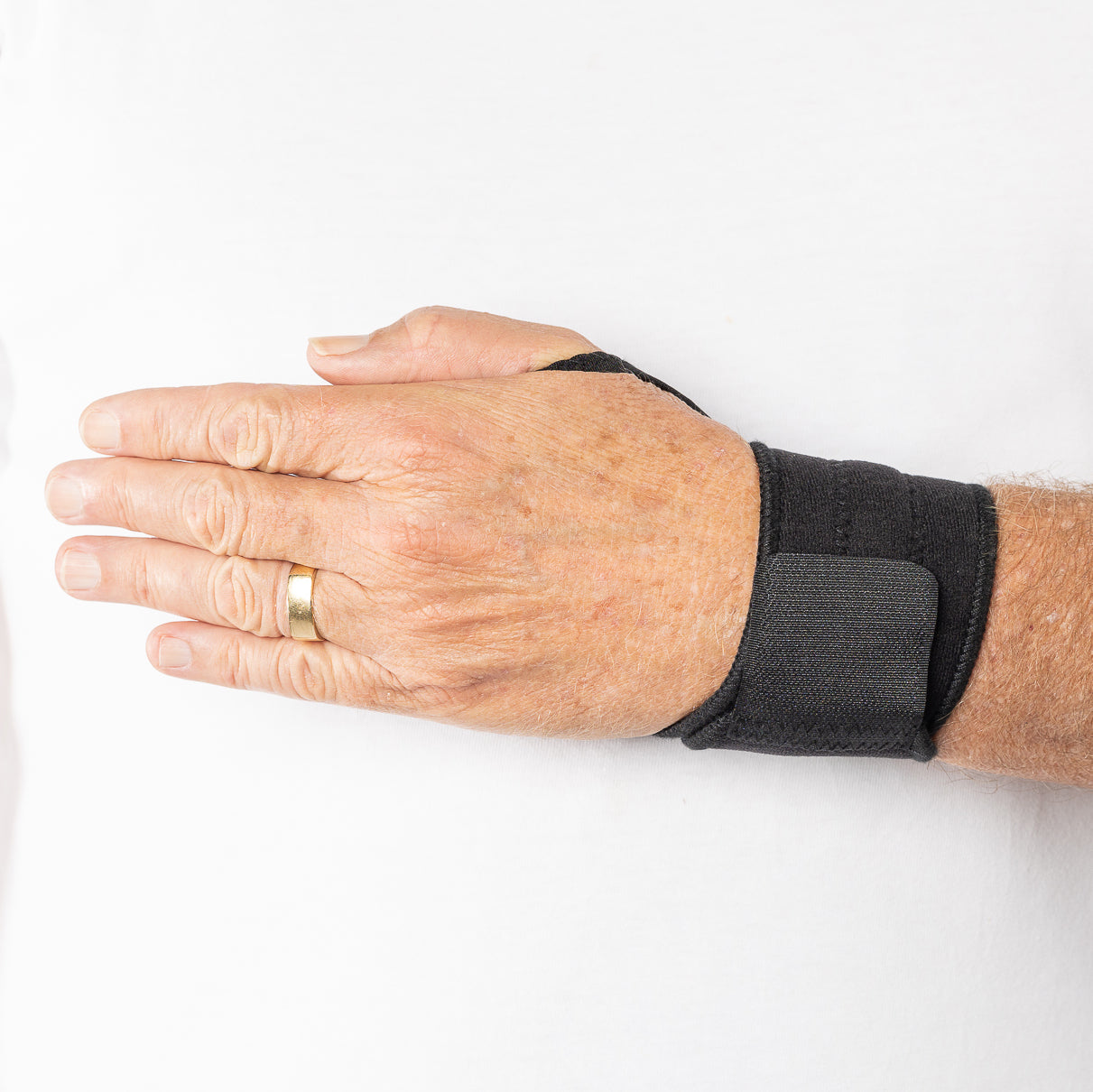 Outside view of the black Bio Magnetic Wrist Support being worn by a man. 
