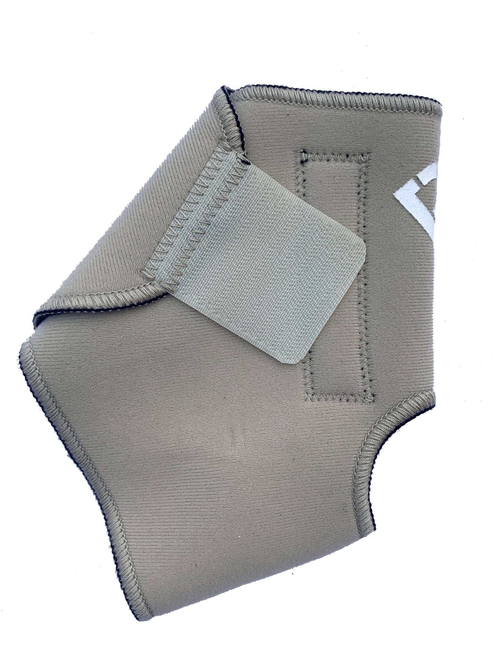 The Bio Magnetic Ankle Support in beige laying flat  with the adhesive closure closed, a strip of 4 of the 8 therapeutic grade magnets can be seen running down the length of the support. The adhesive closure is a slightly lighter colour beige than the neoprene that is used on the support. 