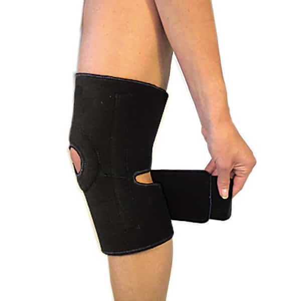 The Bio Magnetic Knee Support in black being fastened with the below strap. 
