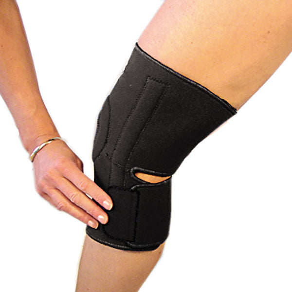 The last step in fastening the bio magnetic knee support in black. The bottom strap is being secured into place just below the knee cap on the left side. 