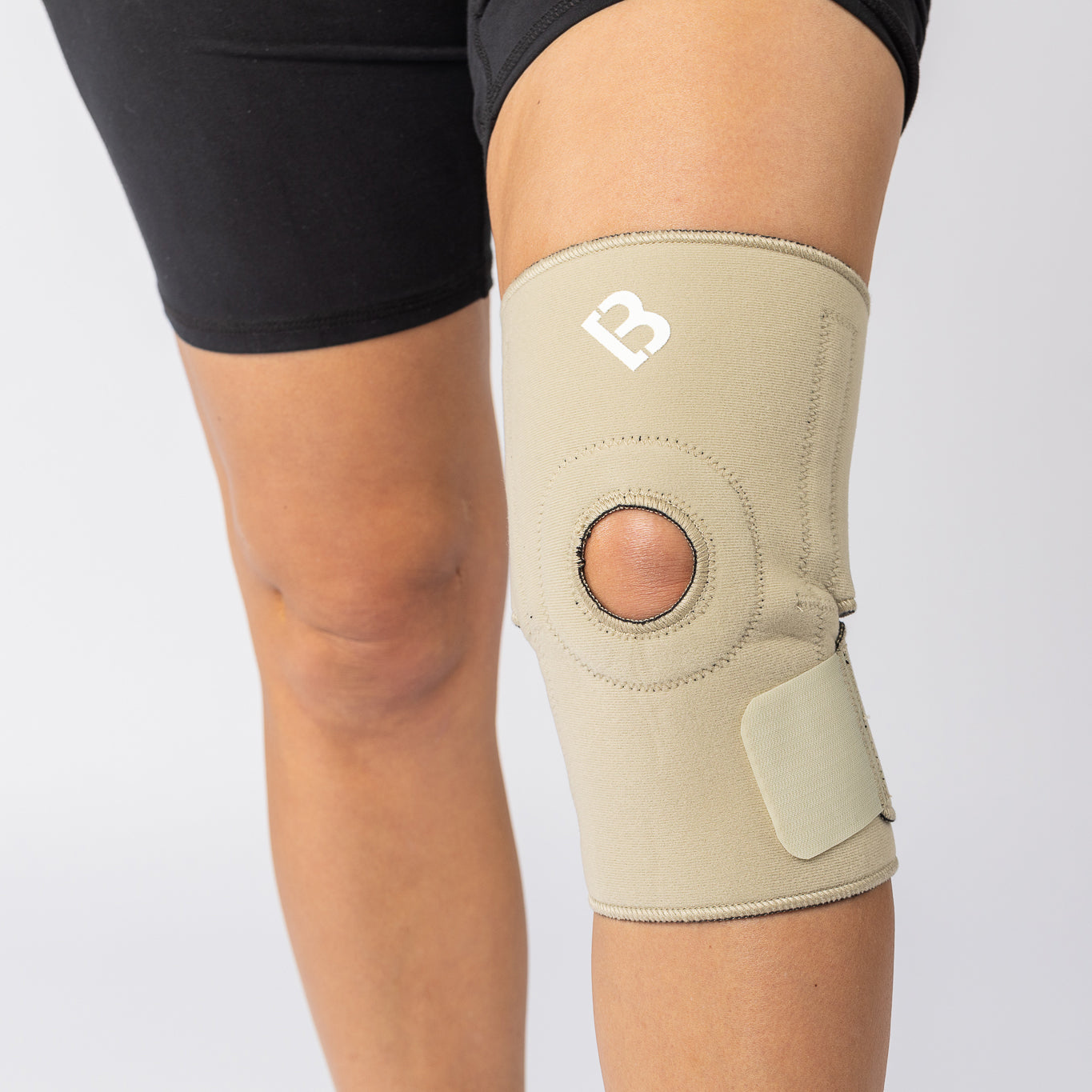 The Bio Magnetic Knee Support in beige being worn by a woman and it is viewed from the front side, showing the excellent fit of the magnetic knee support.